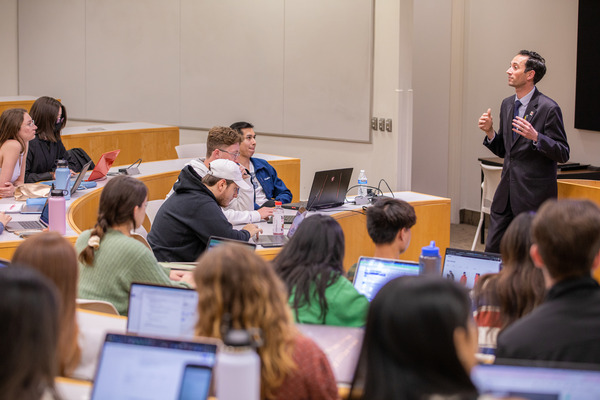 Students and a professor in a lecture-hall style classroom.