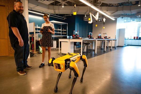 A student and a professor operate a robot dog from Boston Dynamics in Swenson Hall.