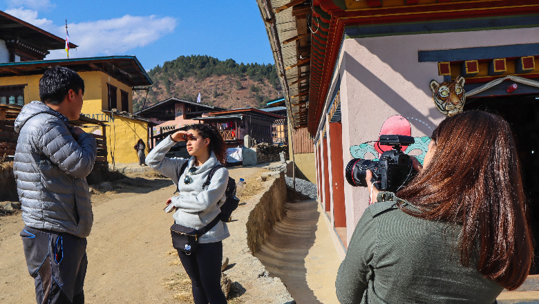 Student filming another student interviewing a local on the street