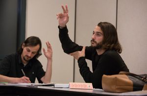 Two students raise their hands in a class