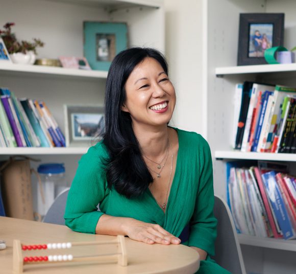 Cathery Yeh Sitting at Desk Smiling