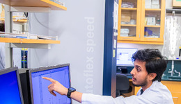 Student pointing at a computer