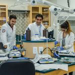 Rinker students wearing lab coats and working in a lab