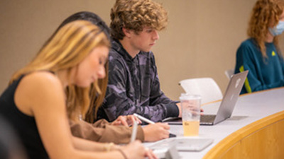 Students at a desk with laptops