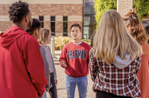 A student tour guide leads a small tour on the Chapman campus.
