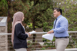 A student and a counselor talking outside.