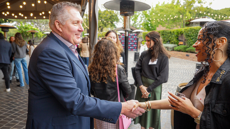 alumni shaking hands at industry event