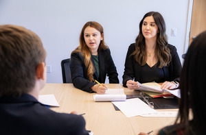 Students looking at a laptop in a conference room.