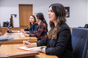 Students sitting in a classroom. They are wearing professional attire.