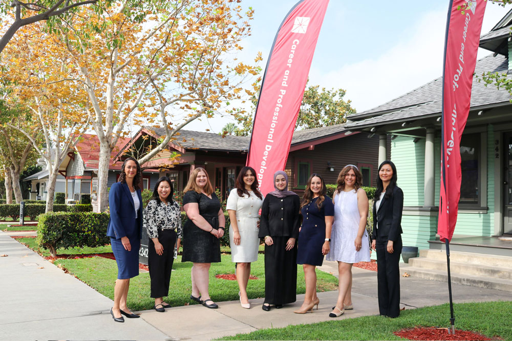 Career team standing in front of green house office