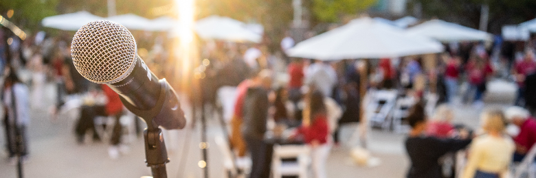 In focus microphone at an event with crowd in background