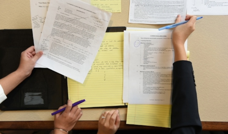 The image shows several college papers being graded.