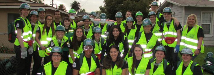 Three students sit outside of the Digital Media Arts Center at Chapman University