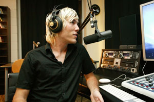 Student DJ in front of microphone running a radio show