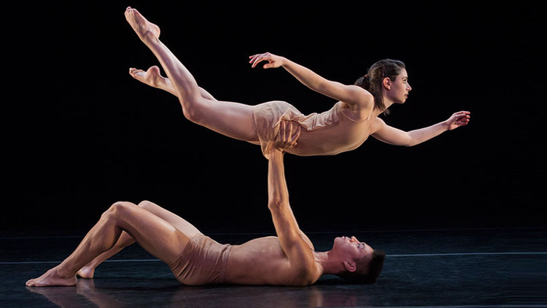male dancer on his back lifting a female dancer above him in horizontal position