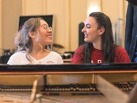 students sitting at a piano