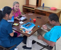 Students working with child in Dominica