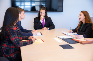 Four students talking in a conference or study room.