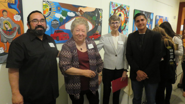 Attallah College Dean Margaret Grogan and Donna Ford Attallah with youth artist standing in front of art at the 2018 Ethnic Studies Summit Youth Art exhibit in Chapman's Leatherby Libraries
