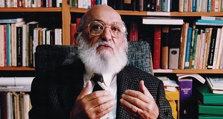 Paulo Freire in front of bookcase