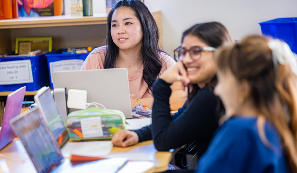 Students at a desk working together.
