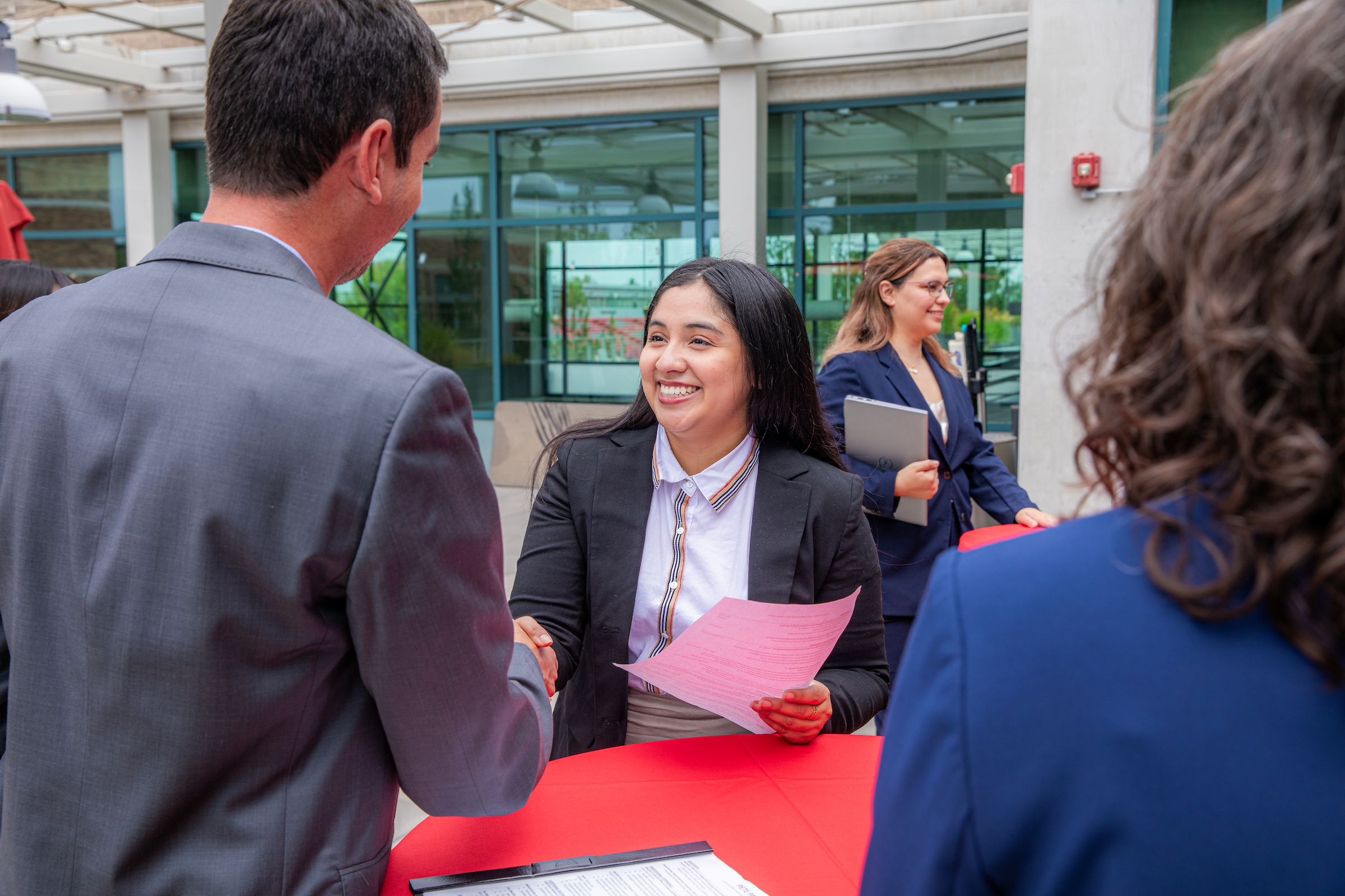 Chapman University student shakes hand of potential emplyer at networking event