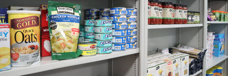 Various cans and jars of food on shelves at Chapman University's Panther Pantry