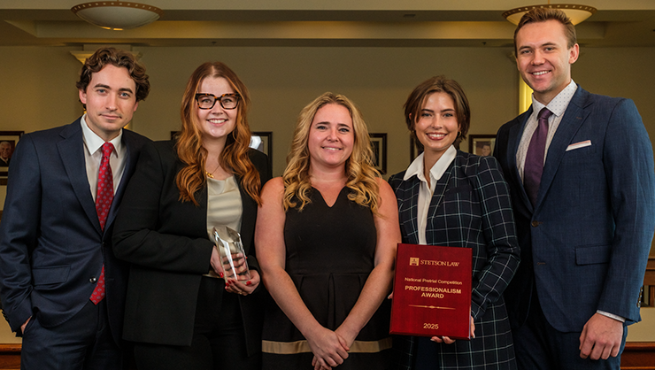 Photo of Chapman student advocacy team posing with 2nd place and Most Professional Team trophies and their coach