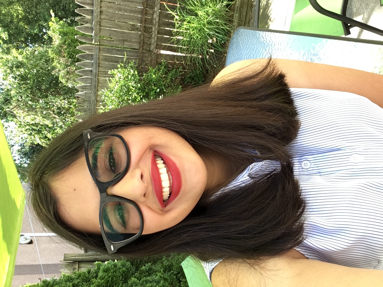 Woman with brown hair, glasses and red lips