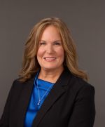 Blond lady in blue shirt and black blazer