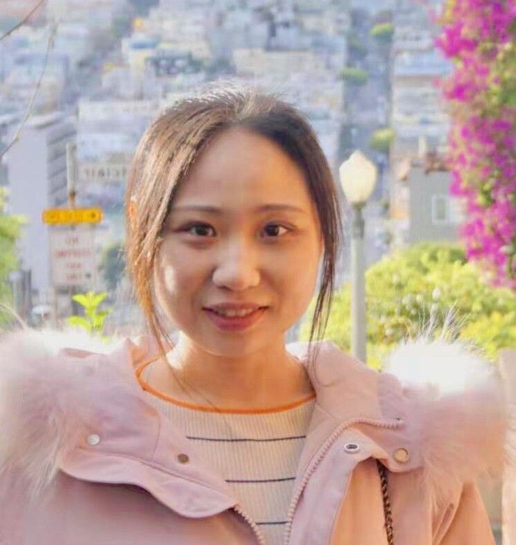 Women with dark hair pulled back, pink jacket. 