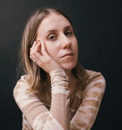 Woman with hand on her face, brown shoulder length hair
