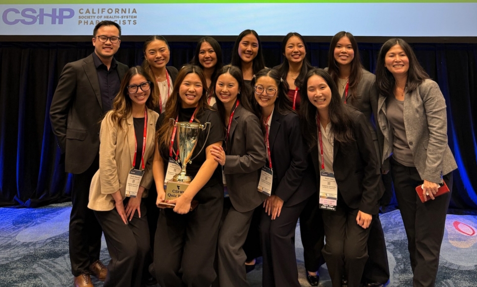 Quiz Bowl team and faculty stand with trophy