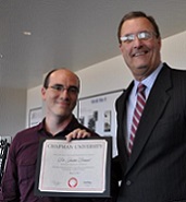 Dr Justin Dressel posting with Award