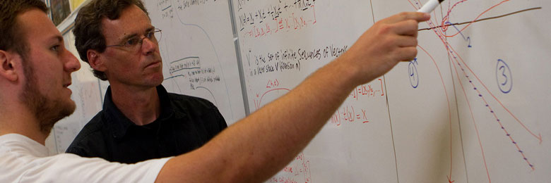 Professor Showing Student Math at Whiteboard