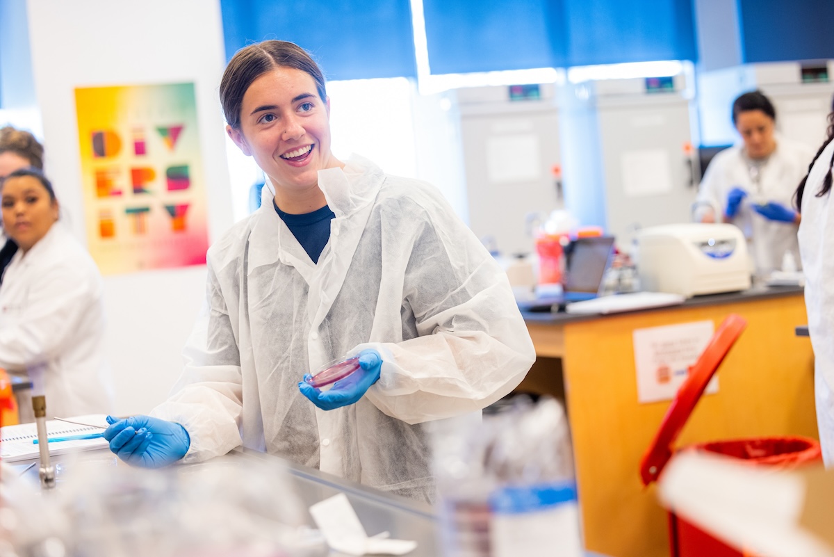 A student performs an experiment in a lab hood.