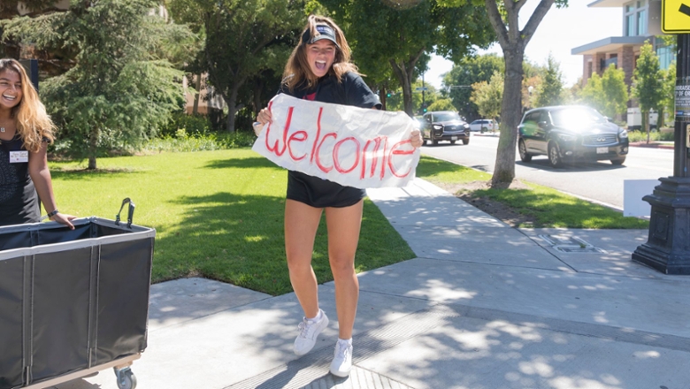Chapman student holding a Welcome sign