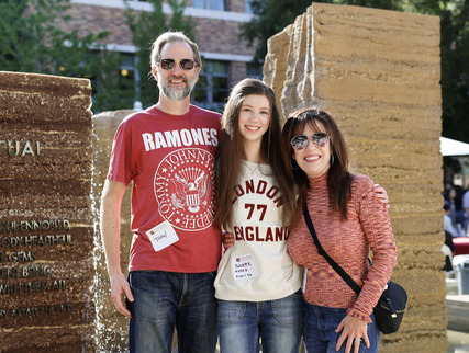 A student with family members standing outside on the Chapman campus.
