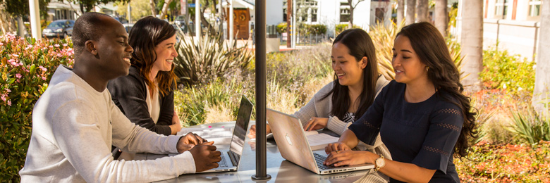 Chapman University graduate students sitting at table outdoors