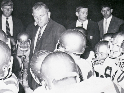 Black and white photo of Dave Currey with football players