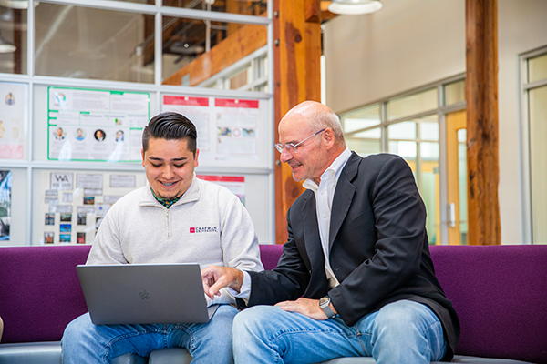 student and faculty looking at a computer