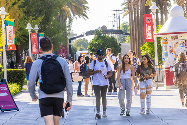 students walking in front of arch