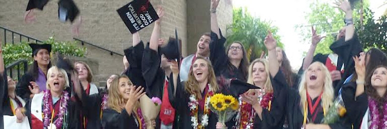 Graduating students throw their caps into the air.