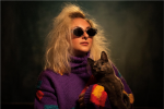 Oona Clarke, Graphic Design ’24 with glasses on, purple sweater, holding a cat.